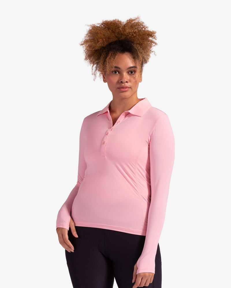 Lady golfer wearing the BloqUV women's long sleeve collared UV shirt in in Tickle Me Pink.