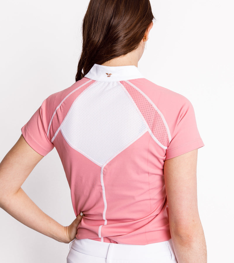 Back view of a woman wearing a short-sleeve pink polo with white stitching and mesh on the back.