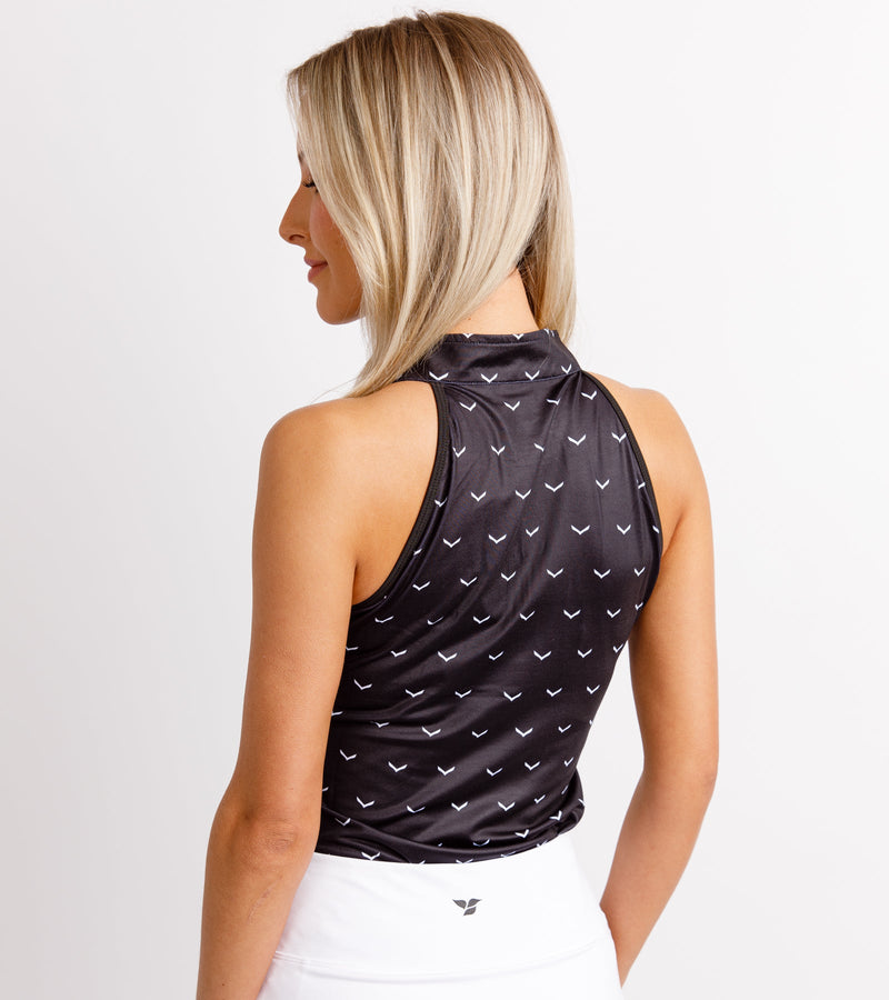  Close-up back view of a woman wearing a sleeveless black polo with a chevron print and high collar.