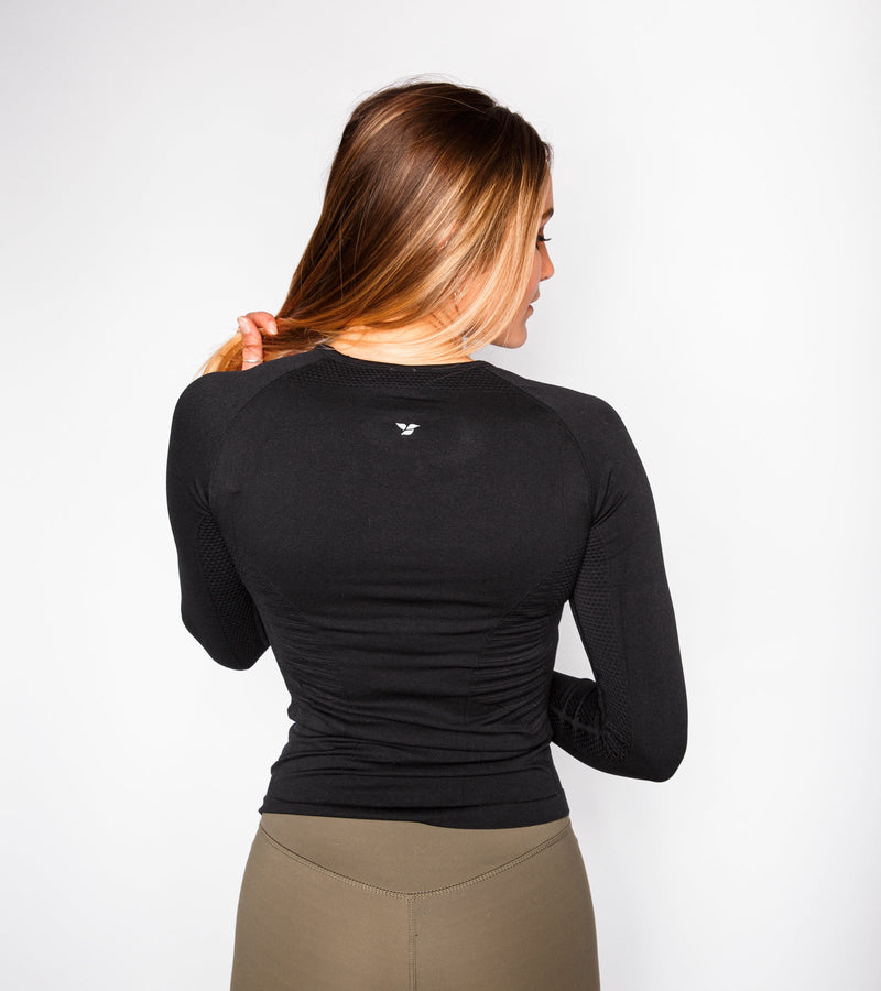 Back view of a woman wearing a long-sleeve black top.