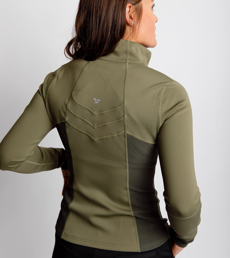 Close-up back view of a woman wearing an army green pullover with chevron stitching on the back.