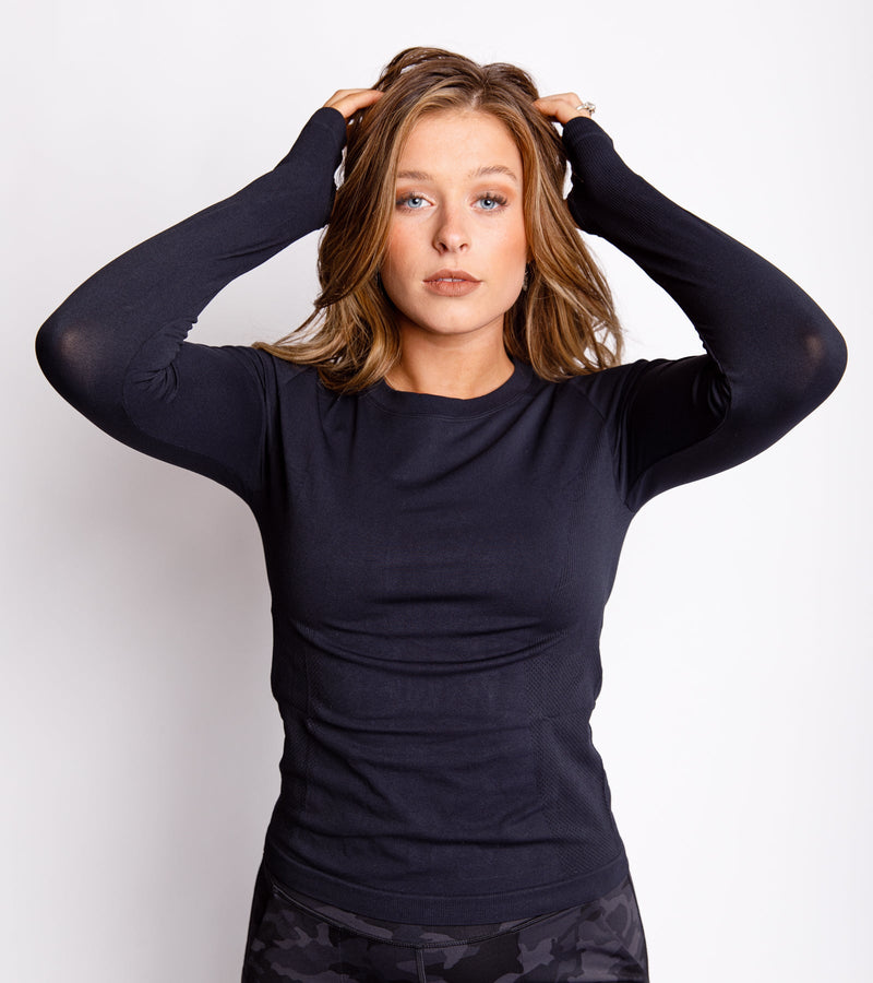 Woman wearing a long-sleeve black compression top.